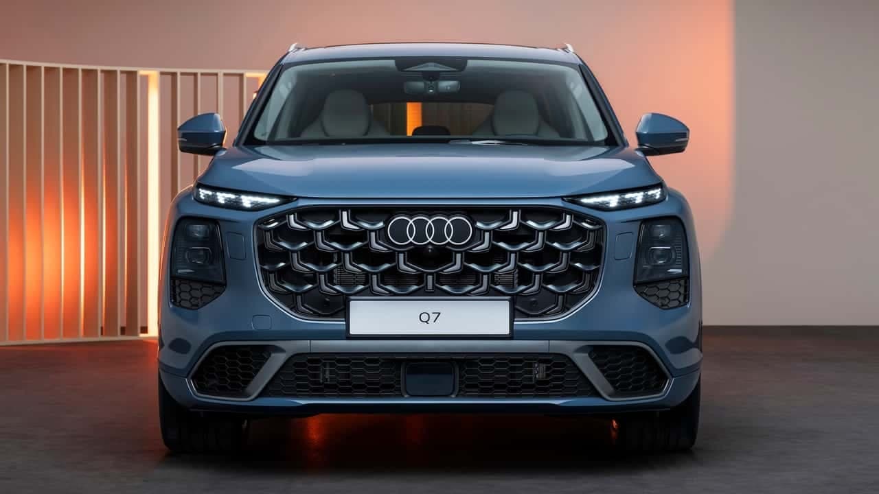 The new Q7's front end — split headlights, a large blacked-out mesh grille, and the illuminated Audi rings.